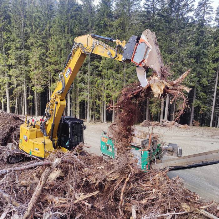 Forstarbeiten mit Bagger zum Sortieren von Rodungsabfällen und Holzresten im Forstgebiet nach Forstarbeiten und Rodungen